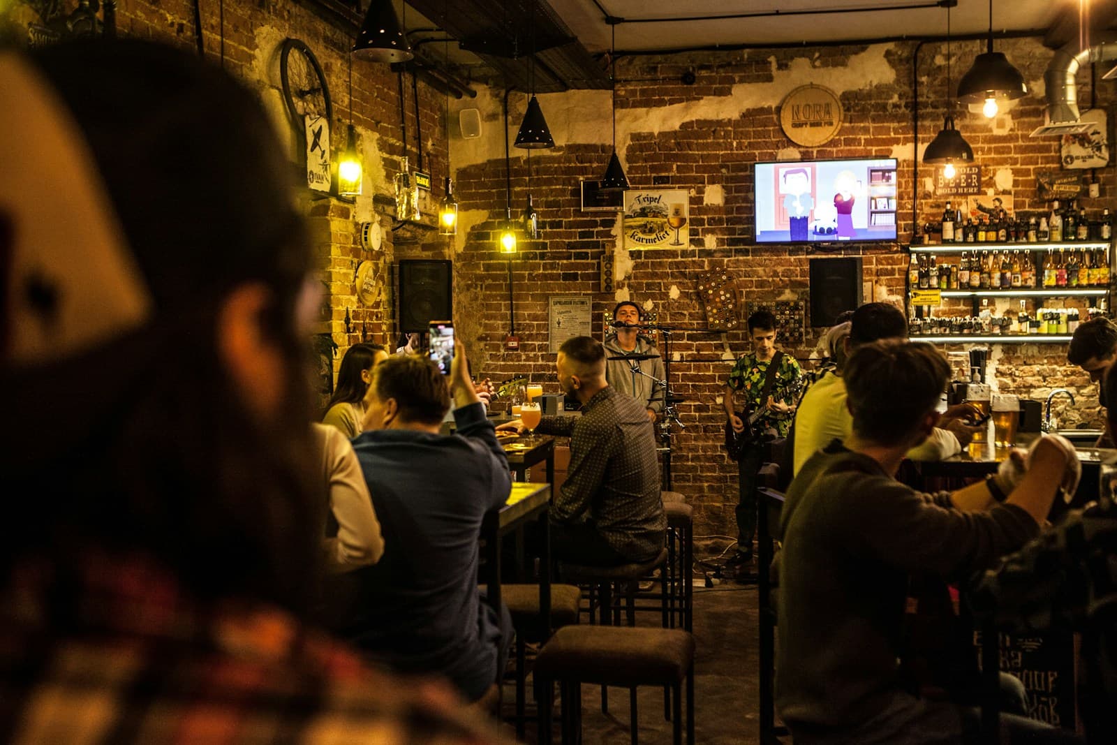 Craft beer pub, full tables, bottles behind the bar