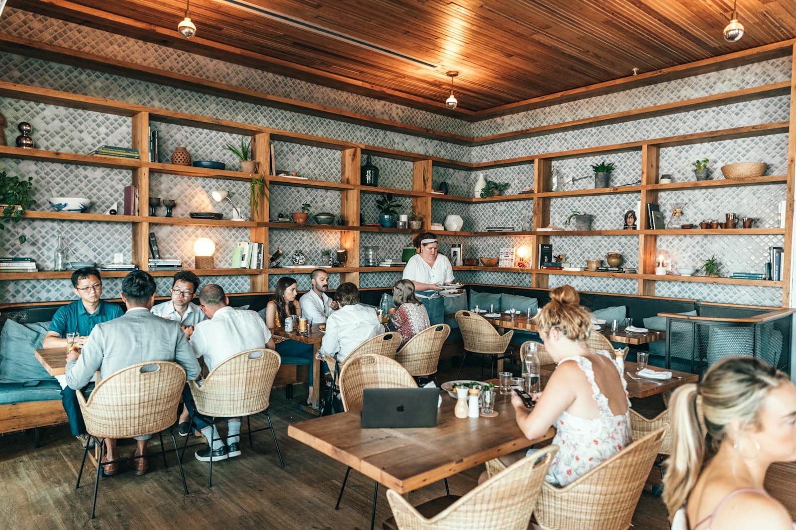 Busy family restaurant, full tables, server carrying plates