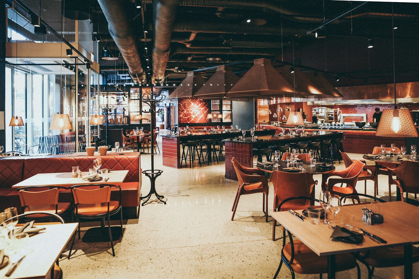 Hotel restaurant with booths, open kitchen and bar counter